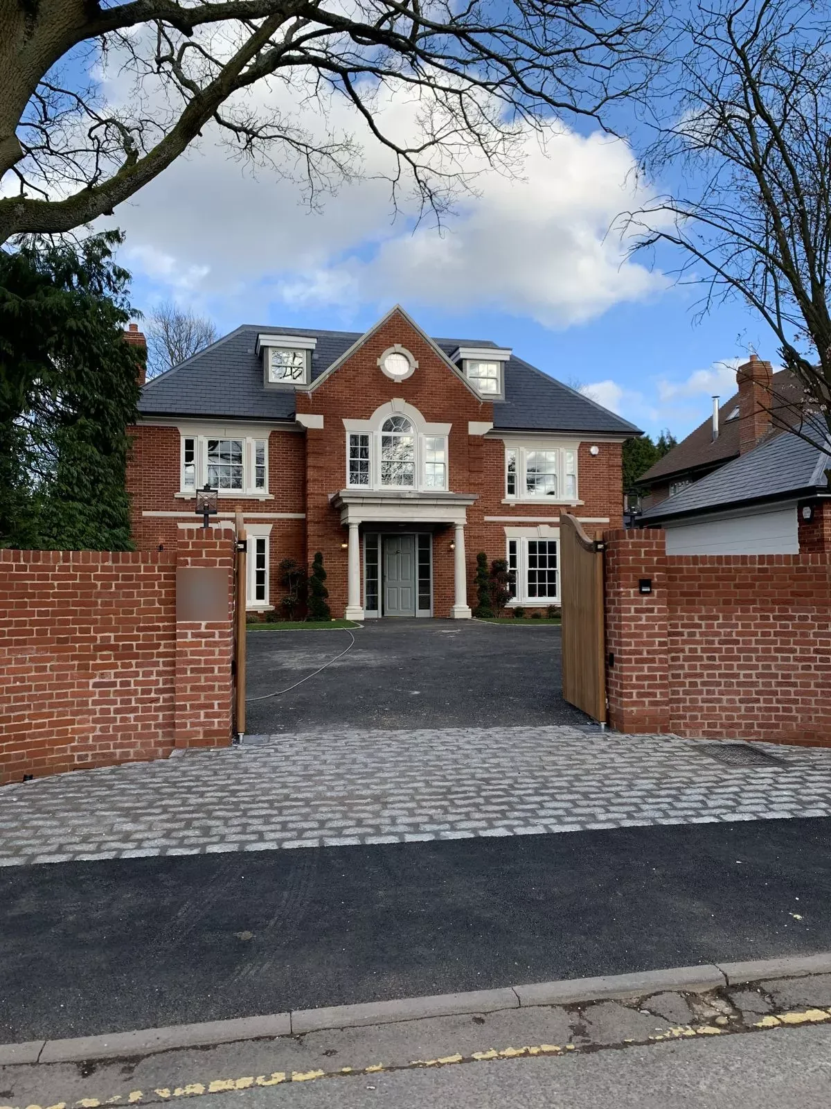 Pillared entrance and gated drive of a finished home